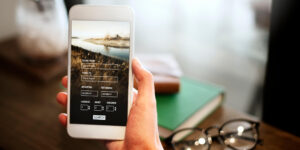 Person using smartphone travel booking app for flight or trip planning