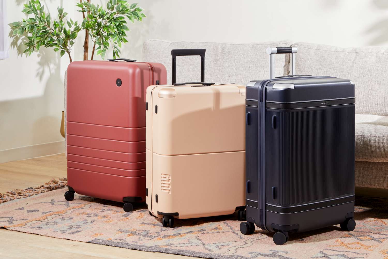 Three modern rolling suitcases arranged inside a furnished living space