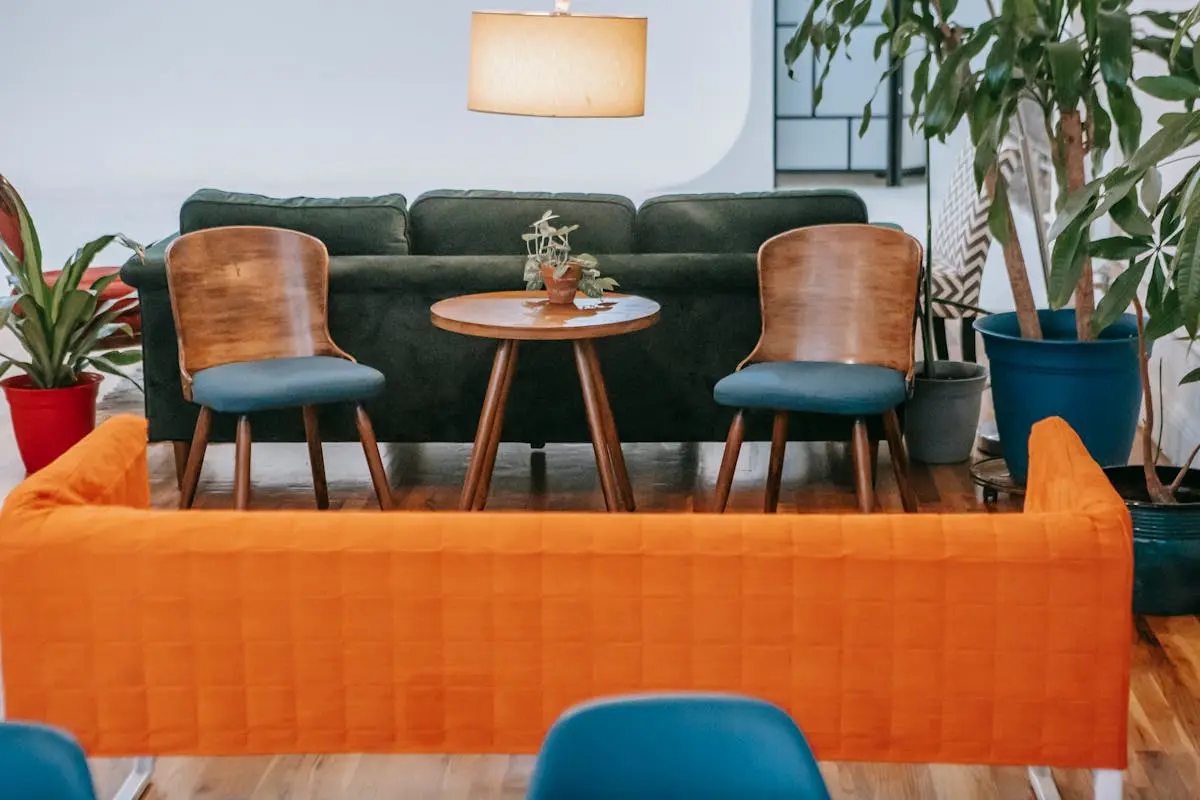 Remote work desk setup inside a furnished apartment with laptop and desktop computer