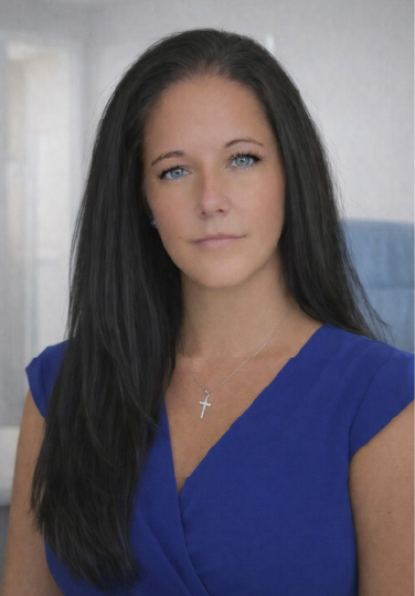 Professional headshot of Ashlee Robinson wearing a blue blouse, photographed against a softly blurred office background.
