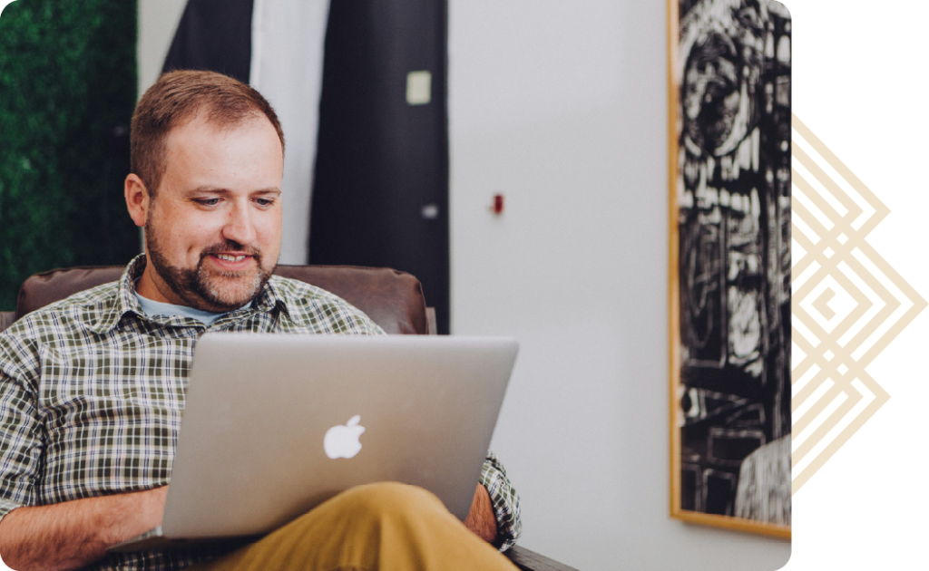 Business professional working on a laptop with Luxury Corporate Lodging branding overlay
