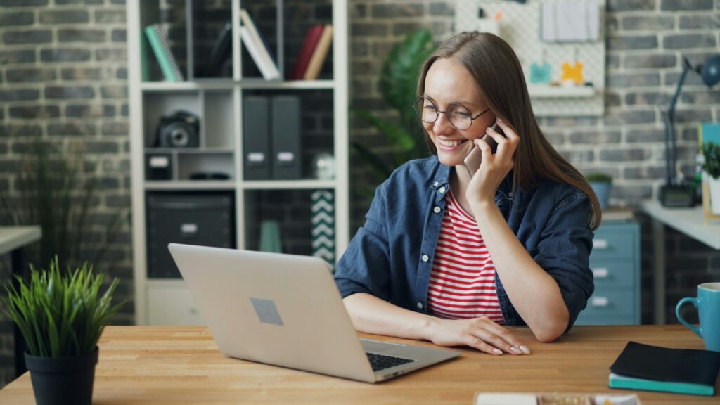 Business professional working remotely while speaking on the phone from a home office setup