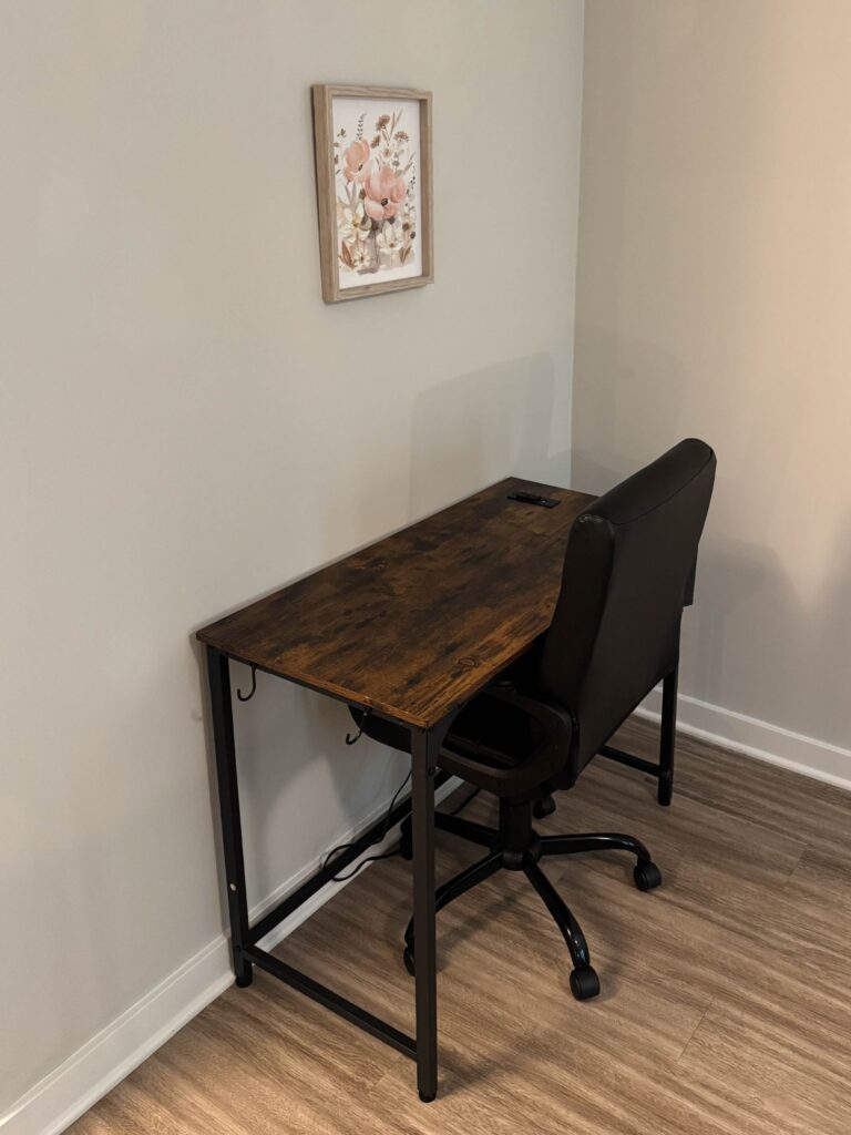 Dedicated workspace featuring a writing desk, rolling office chair, and nearby power access, providing a comfortable area for remote work, online meetings, or trip planning.