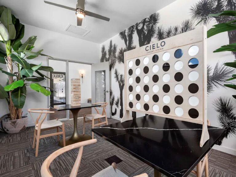 Resident clubhouse lounge at Cielo Luxury Living featuring a large Connect Four game, modern seating areas, contemporary décor, and collaborative gathering spaces.