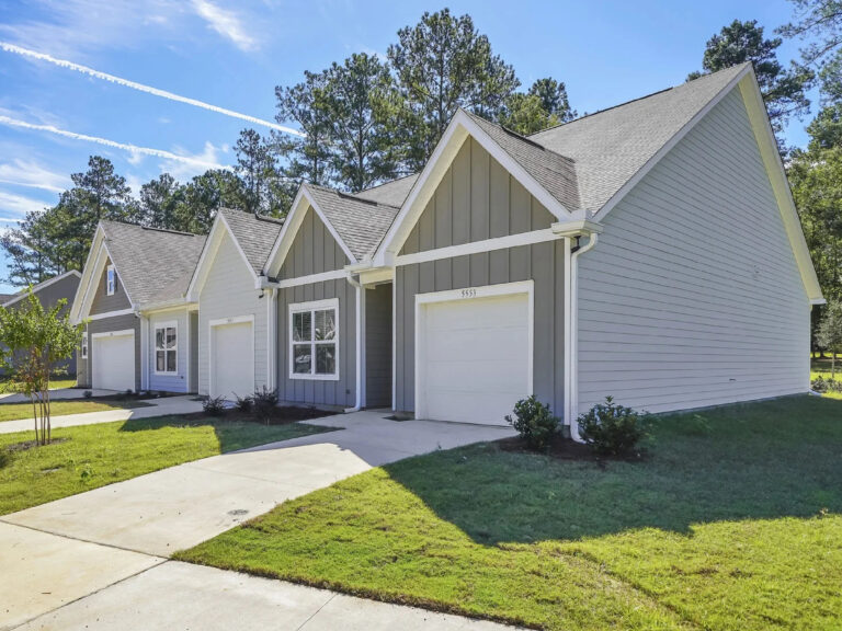 Exterior view of modern Covey Homes single-story rental homes with attached garages, landscaped lawns, and private driveways.