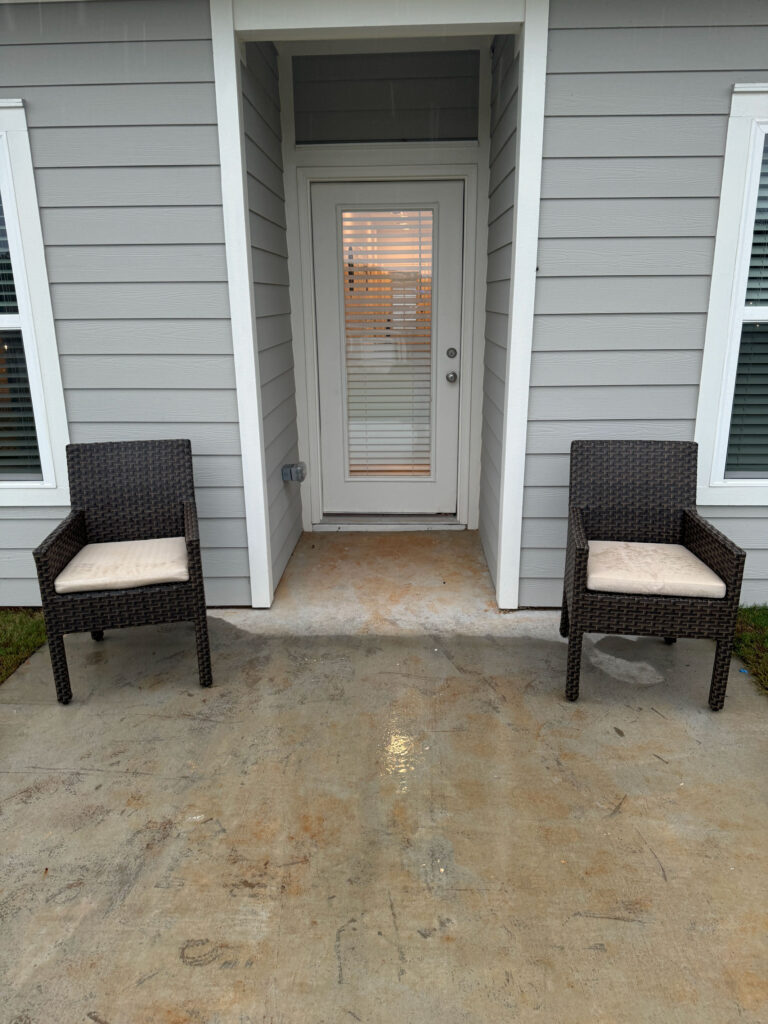 Private covered patio at Covey Homes with outdoor seating and direct access to the home.
