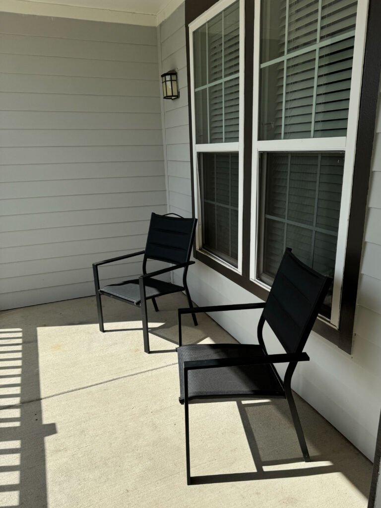 Private covered patio seating area at Evergreen at Southwood in Tallahassee with outdoor chairs and residential style comfort