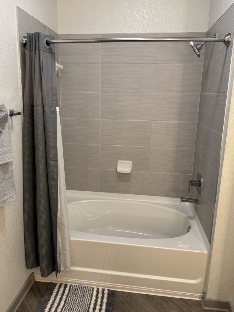 Modern bathroom with a tiled shower and bathtub combination, neutral finishes, and clean contemporary design.