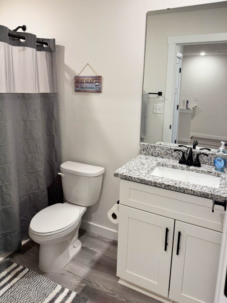 Full bathroom with a granite vanity, modern fixtures, shower and tub combination, and contemporary finishes.