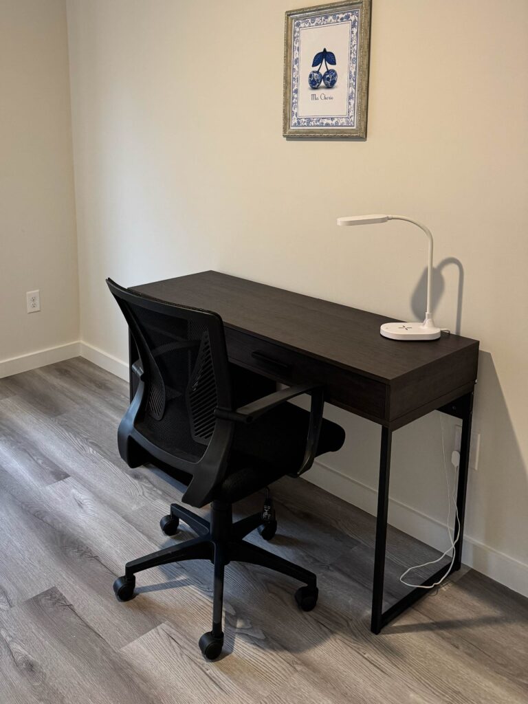 Dedicated workspace featuring a modern desk, ergonomic office chair, task lighting, and ample room for remote work.