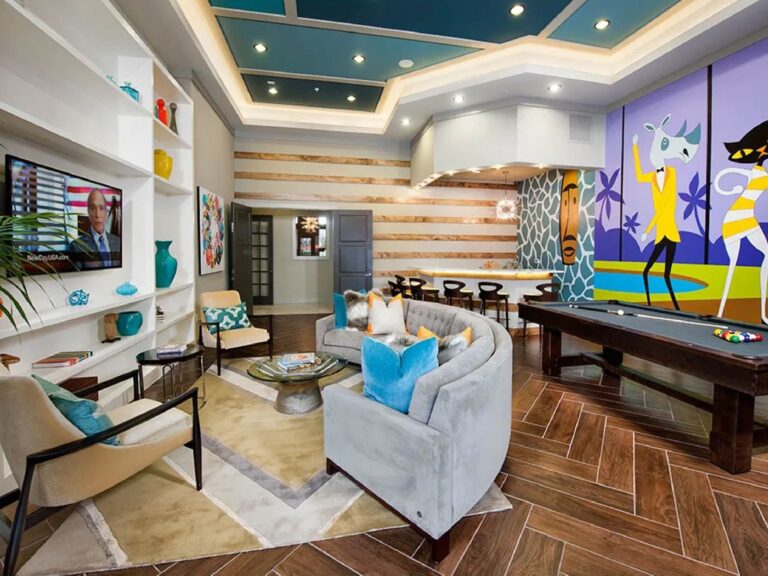 Modern resident clubhouse with lounge seating, pool table, colorful wall mural, and entertainment space.