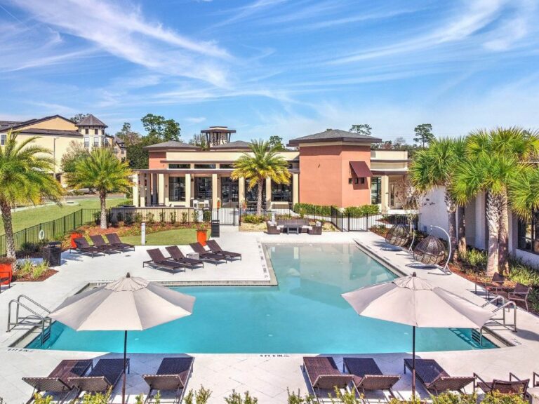 Resort style outdoor swimming pool at Maxwell Apartments in Nashville featuring expansive sundecks, lounge seating, palm trees, and luxury apartment community amenities.