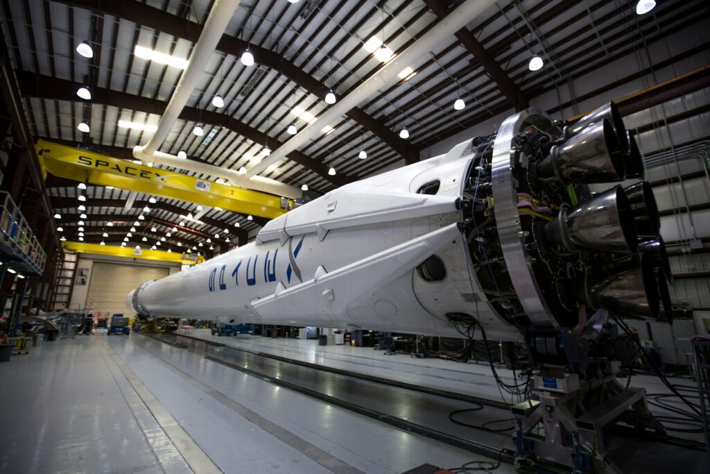Aerospace rocket undergoing assembly and testing inside a large aerospace manufacturing facility, representing aerospace engineering, defense, and space exploration industries.