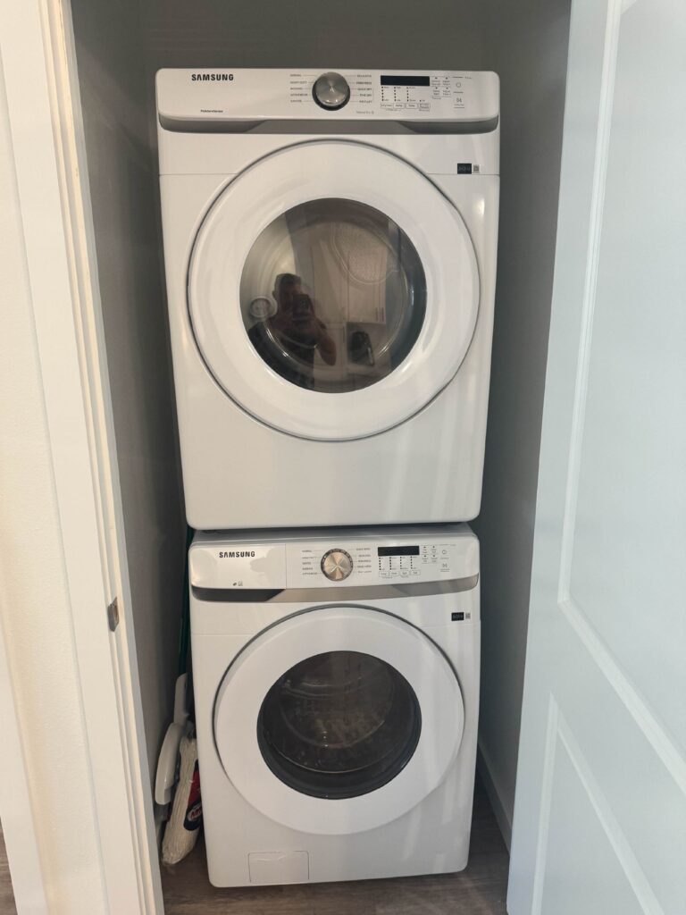 Stackable Samsung washer and dryer set inside a dedicated in-unit laundry closet.