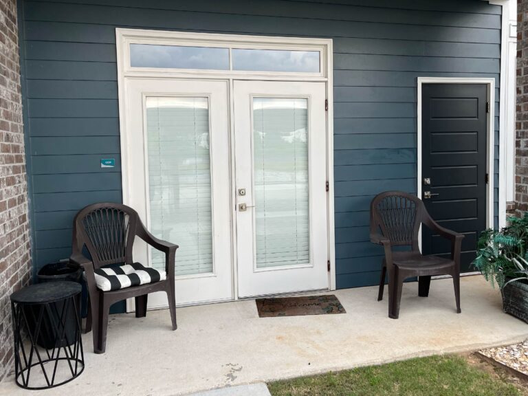 Private ground-floor patio at Oasis at Southpark featuring outdoor seating, dual entry doors, and a comfortable space for relaxing outdoors.