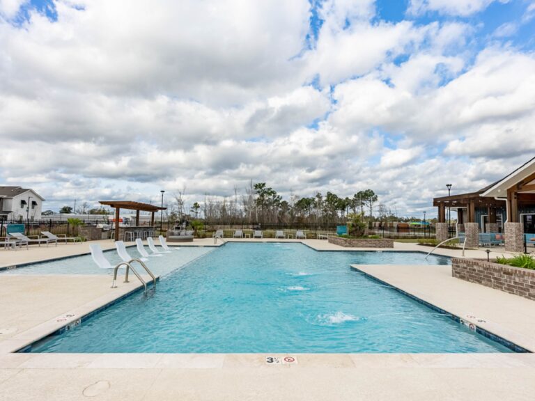 Resort-style swimming pool at Oasis at Southpark featuring a spacious sun deck, in-water lounge chairs, fountains, and outdoor gathering spaces.