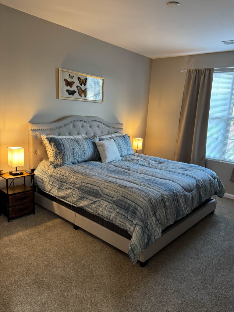Spacious bedroom with a king size bed, upholstered headboard, bedside lighting, and soft neutral décor.