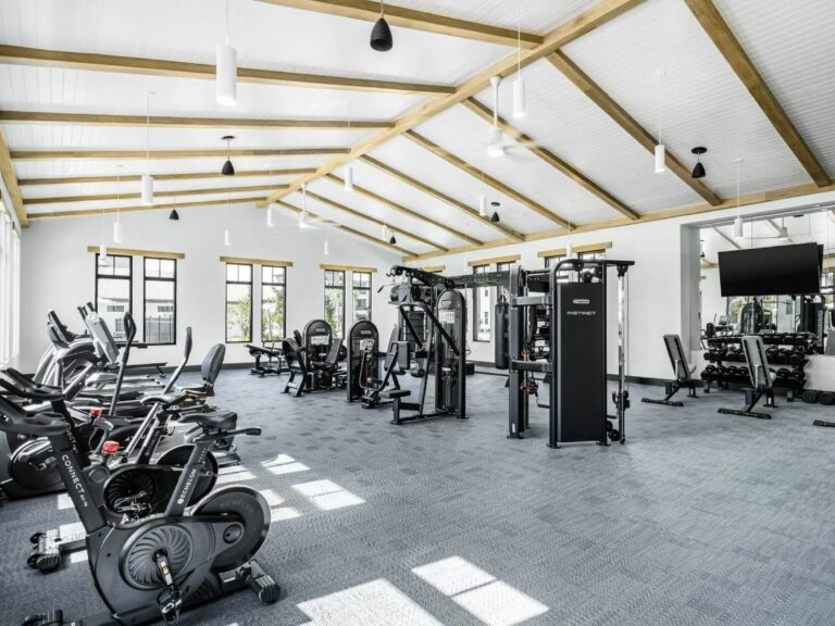 Modern fitness center at Sorrento Apartments in Sarasota featuring cardio machines, strength training equipment, and upscale wellness amenities