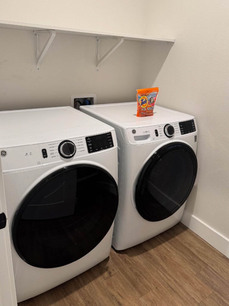Full size in unit washer and dryer at Sorrento Apartments with modern front loading appliances and laundry essentials