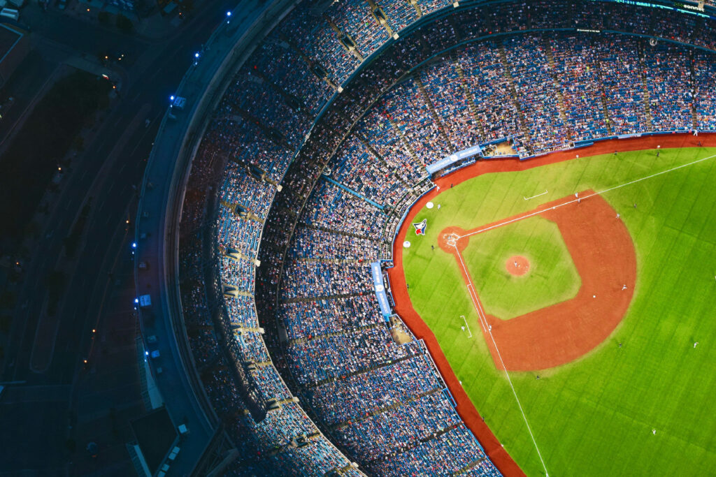 Aerial view of a packed professional sports stadium during a live baseball game, representing the sports and entertainment industry workforce.
