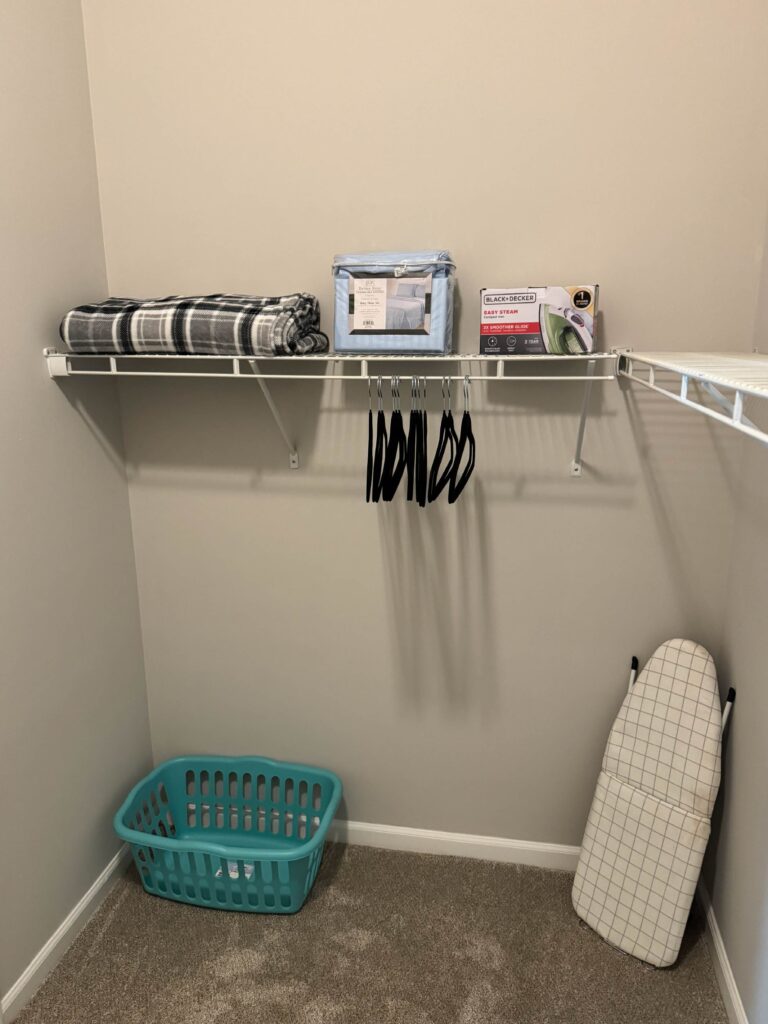 Walk in closet at Tapestry Bocage featuring built in shelving, hanging space, laundry basket, ironing board, and additional storage essentials.