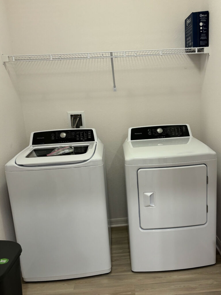 In unit washer and dryer set inside a dedicated laundry space at V2 Apartments in Fort Myers.