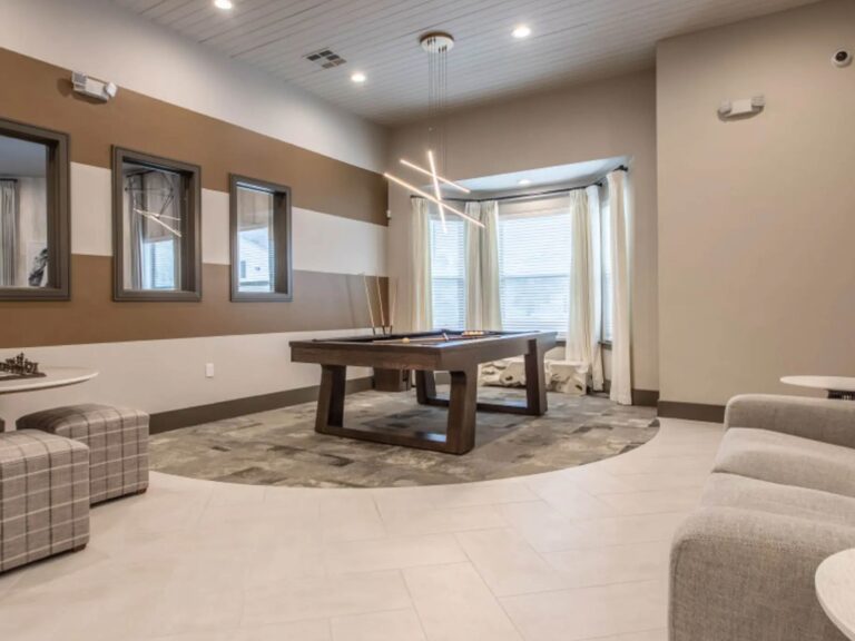 Modern resident lounge at Vale Apartments in the Spring/Houston area featuring a billiards table, comfortable seating, contemporary lighting, and inviting gathering spaces.