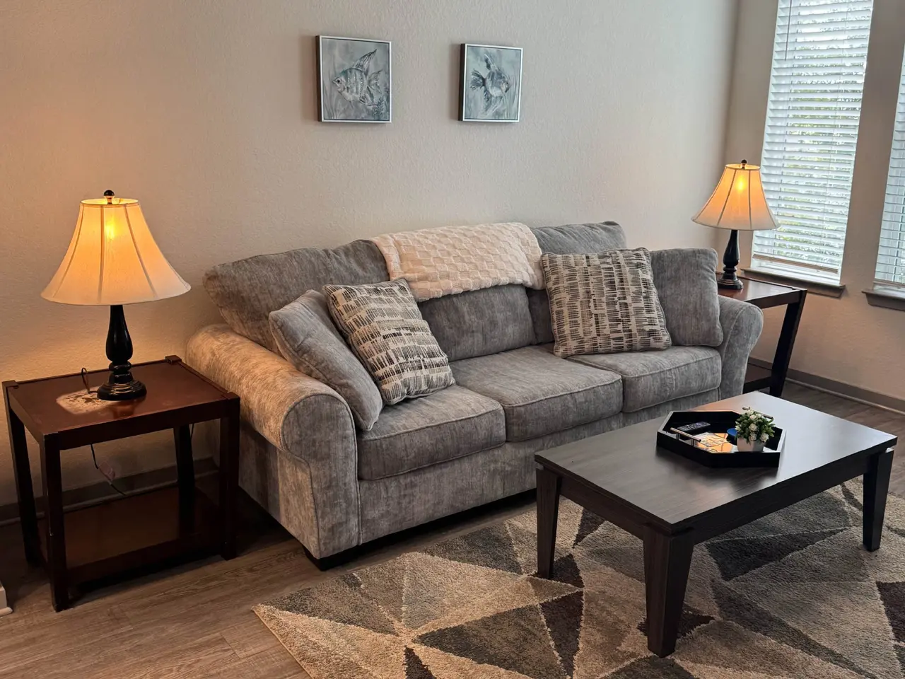 Furnished corporate housing living room with sofa, coffee table, and warm lighting