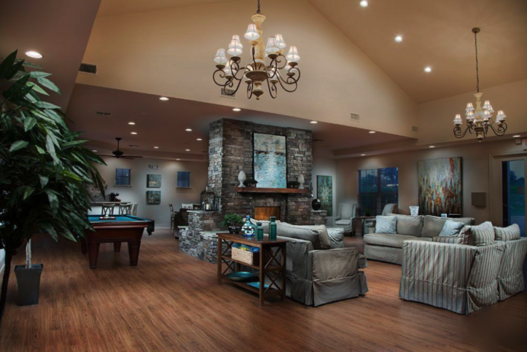 Elegant resident clubhouse featuring lounge seating, fireplace, billiards table, high ceilings, and gathering spaces at Mill at McCullough Apartments in Tupelo, Mississippi.