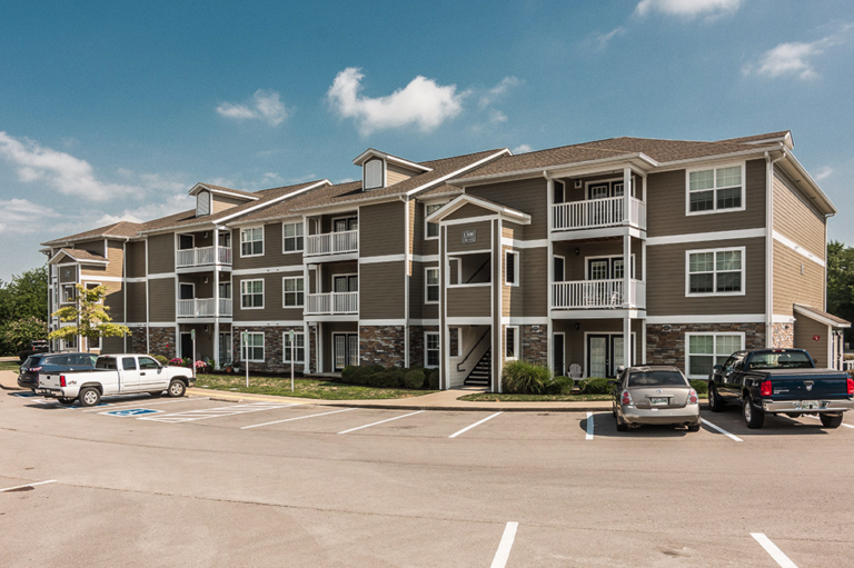 Exterior view of Waterford Crossing apartments in Nashville featuring modern three-story residential buildings, private balconies, landscaped grounds, and convenient resident parking.