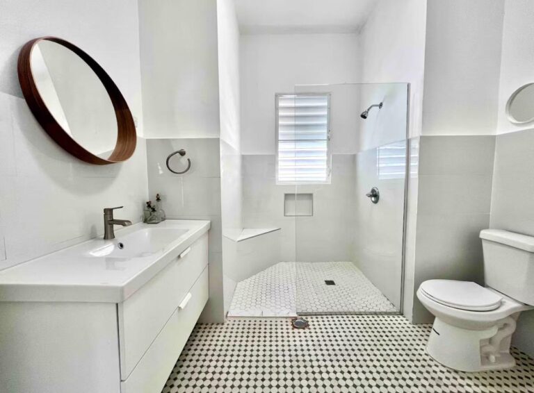 Modern Puerto Rico bathroom with walk-in glass shower, contemporary vanity, and patterned tile flooring.