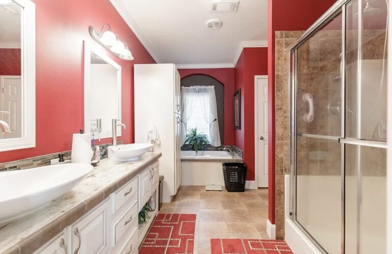 Spacious primary bathroom featuring dual vessel sinks, a large walk-in shower, soaking tub, and elegant red accent walls.