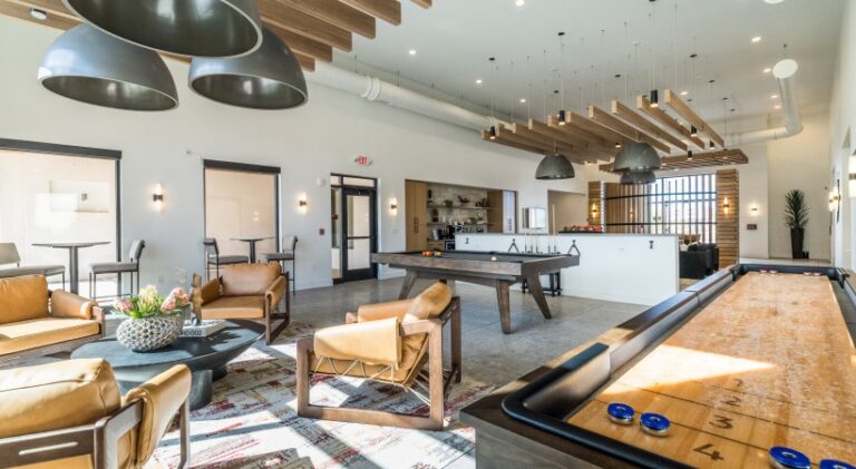Modern resident clubhouse at Solwyn Santa Fe featuring shuffleboard, billiards, lounge seating, and collaborative gathering spaces.